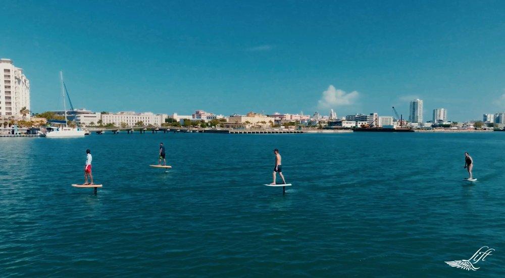 group of people in the water on efoil boards